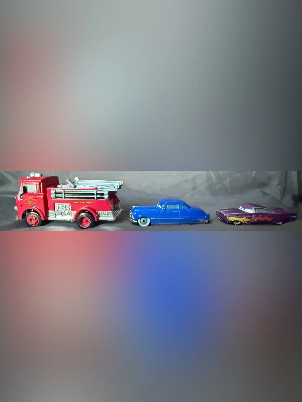 Disney Pixar Cars Diecast: Red Fire Truck, Doc Hudson, and Purple Ramon.